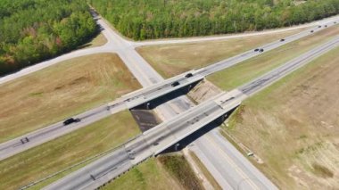 Elevated view of freeway exit junction over road lanes with fast moving traffic cars and trucks. Interstate transportation infrastructure in USA.