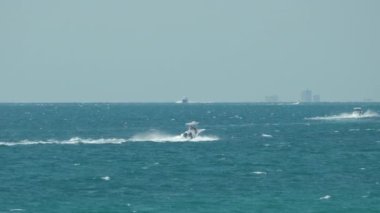 Sürat teknesi dalgalanma yüzeyi ile deniz dalgalarında hızlı yüzüyor. Motorlu tekne yüksek hızda okyanusta hareket ediyor..