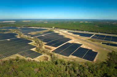 Temiz elektrik enerjisi üretmek için birçok sıra güneş fotovoltaik paneli bulunan sürdürülebilir büyük elektrik santralinin havadan görünüşü. Sıfır emisyon kavramı ile yenilenebilir elektrik.