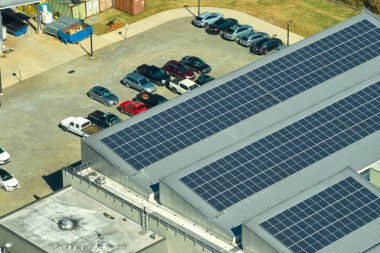 Sanayi binasının çatısına yeşil ekolojik elektrik üretmek için monte edilen mavi fotovoltaik güneş panellerinin hava görüntüsü. Sürdürülebilir enerji konsepti üretimi.