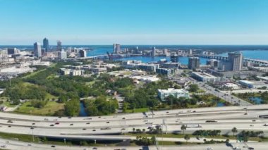 Jacksonville şehrinin hava manzarası. Yüksek ofis binaları ve hızlı araba ve kamyonlarla Amerikan otoyolu kavşağı. ABD ulaşım altyapısının üstünden görüntüle.
