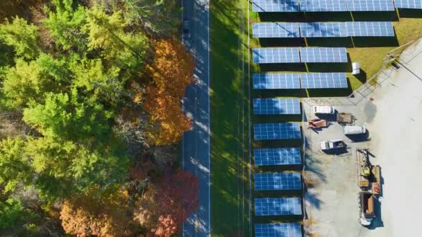 クリーンな電気エネルギーを生成するための太陽光発電パネルの行を持つ大規模な持続可能な電気発電所の空中ビュー 排出ゼロの再生可能エネルギーの概念 — ストック動画