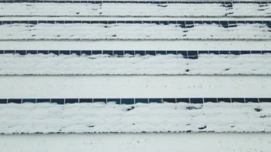 Aerial view of sustainable electrical power plant with solar photovoltaic panels covered with snow in winter for producing clean energy. Concept of low effectivity of renewable electricity in north.