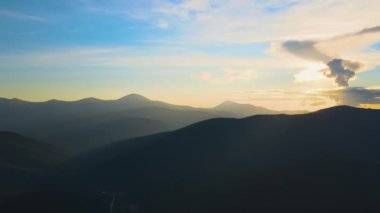 Gün batımında puslu tepeleri ve sisli vadisi olan güzel dağ panoramik manzarası.