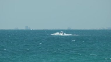 Sürat teknesi dalgalanma yüzeyi ile deniz dalgalarında hızlı yüzüyor. Motorlu tekne yüksek hızda okyanusta hareket ediyor..