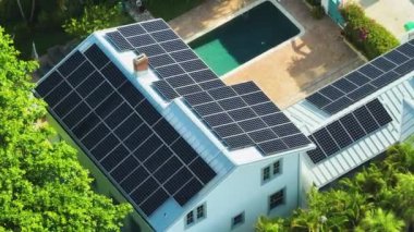 Temiz ekolojik elektrik enerjisi üretmek için mavi güneş fotovoltaik panelleri olan pahalı Amerikan binasının çatısı. Emeklilik geliri kavramı için yenilenebilir elektriğe yatırım.