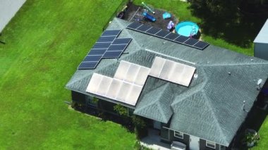 Temiz ekolojik elektrik enerjisi üretmek için mavi güneş fotovoltaik panelleri olan normal Amerikan ev çatısı. Emeklilik geliri için yenilenebilir elektriğe yatırım.