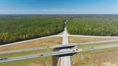 Elevated view of freeway exit junction over road lanes with fast moving traffic cars and trucks. Interstate transportation infrastructure in USA.