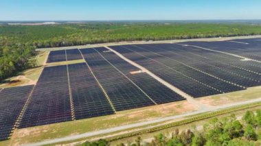 Temiz elektrik enerjisi üretmek için birçok sıra güneş fotovoltaik paneli bulunan sürdürülebilir büyük elektrik santralinin havadan görünüşü. Sıfır emisyon kavramı ile yenilenebilir elektrik.