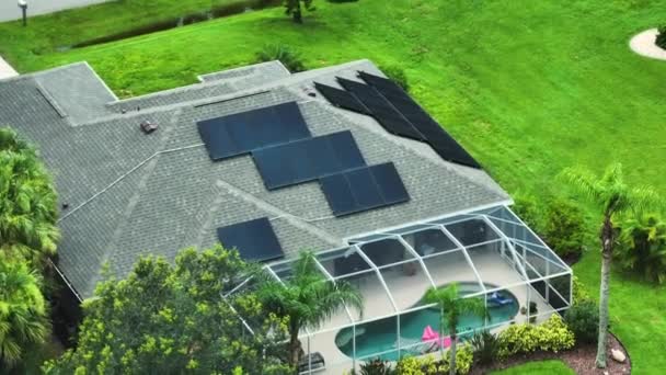 きれいな生態系の電気エネルギーを生成するための青い太陽光発電パネルと高価なアメリカの家庭の屋根の空中ビュー 退職所得の再生可能エネルギーへの投資 — ストック動画
