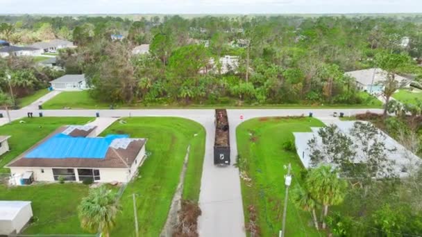 飓风伊恩从空中俯瞰着从佛罗里达街头捡来植被碎片的回收垃圾车 处理自然灾害的后果 — 图库视频影像