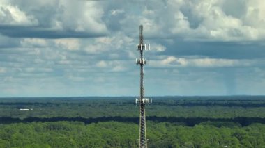 Aerial view of telecommunications cell phone tower with wireless communication 5g antennas for network signal transmission.