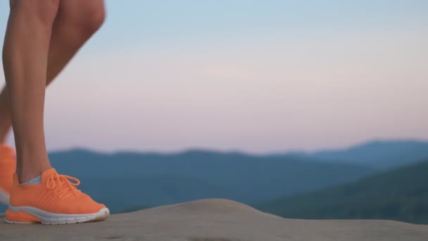 夏天的傍晚 穿着鲜亮橙色运动鞋站在登山道上的年轻女子细腿的衣服 积极的生活方式 大自然的慢跑和新鲜空气概念的锻炼 — 图库视频影像