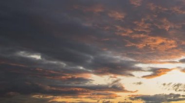 Gün batımında mavi gökyüzünde hızla hareket eden bulutların hızlandırılmış görüntüleri.