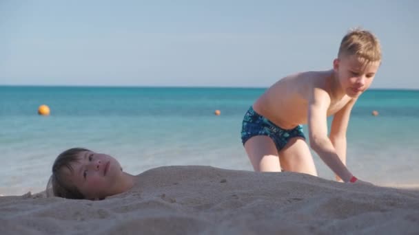 Two Kids Play Beach Laughing Boy Covers Smiling Girl White — Vídeo de stock