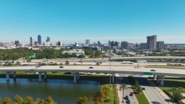 Jacksonville şehrinin hava manzarası. Yüksek ofis binaları ve hızlı araba ve kamyonlarla Amerikan otoyolu kavşağı. ABD ulaşım altyapısının üstünden görüntüle.
