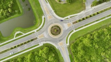Aerial view of road roundabout intersection with moving cars traffic. Rural circular transportation crossroads.