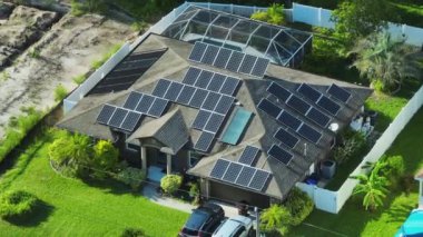 Temiz ekolojik elektrik enerjisi üretmek için mavi güneş fotovoltaik panelleri olan normal Amerikan ev çatısı. Emeklilik geliri için yenilenebilir elektriğe yatırım.