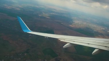 Kara fırtına bulutları arasında uçarken hava türbülansından sallanan jet uçağı kanadının görüntüsü. Seyahat ve hava taşımacılığı kavramı.