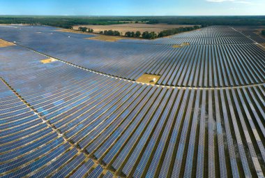 Temiz elektrik enerjisi üretmek için birçok sıra güneş fotovoltaik paneli bulunan sürdürülebilir büyük elektrik santralinin havadan görünüşü. Sıfır emisyon kavramı ile yenilenebilir elektrik.