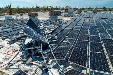 Yeşil ekolojik elektrik üretmek için endüstriyel yapı çatısına monte edilen rüzgar fotovoltaik güneş panellerinden hasar gören hava görüntüsü. Doğal afetin sonuçları..