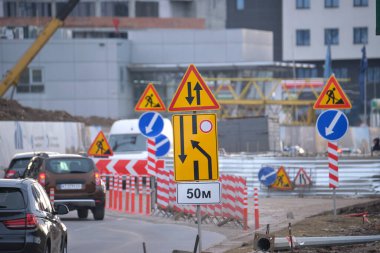 Yol çalışmaları trafik işaretlerini uyardı. Şehir caddesinde inşaat çalışması ve yavaş hareket eden arabalar..