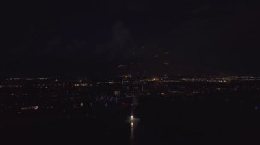 Aerial view of bright fireworks exploding with colorful lights over sea shore on US Independence day holiday.