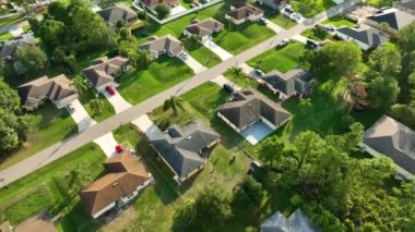 Florida 'nın sakin yerleşim bölgesinde yeşil palmiye ağaçları arasında özel evleri olan küçük bir Amerikan banliyö manzarası..