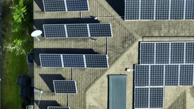 Aerial view of typical american building roof with rows of blue solar photovoltaic panels for producing clean ecological electric energy. Renewable electricity with zero emission concept.