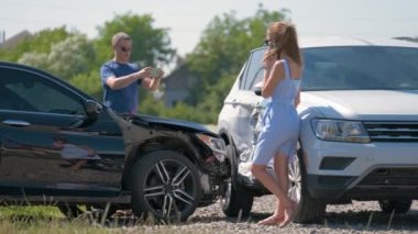 Stresli kadın ve erkek sürücüler trafik kazası üstüne trafik kazası sonrası cep telefonu kamerasıyla fotoğraf çekiyorlar. Yol güvenliği ve sigorta kavramı.