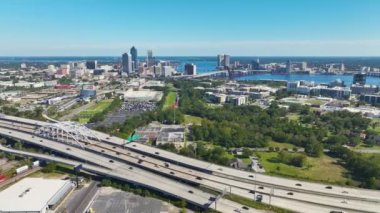 Jacksonville şehrinin hava manzarası. Yüksek ofis binaları ve hızlı araba ve kamyonlarla Amerikan otoyolu kavşağı. ABD ulaşım altyapısının üstünden görüntüle.