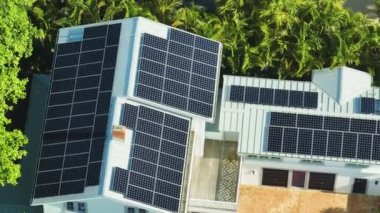 Temiz ekolojik elektrik enerjisi üretmek için mavi güneş fotovoltaik panelleri olan yeni pahalı Amerikan binasının çatısı. Sıfır emisyon kavramı ile yenilenebilir elektrik.