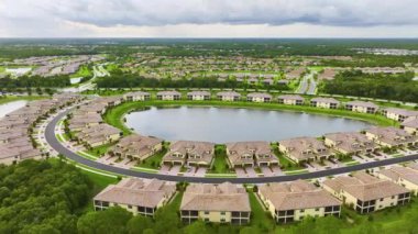 Florida 'da göl suyu olan kapalı yaşam kulüplerinin hava manzarası. Amerikan banliyölerinde emlak gelişimine örnek olarak aile evleri.