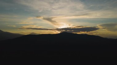 Gün batımında puslu tepeleri ve sisli vadisi olan güzel dağ panoramik manzarası.