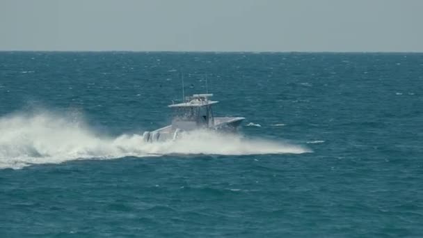 波打つ波の上でスピードボートが速く泳ぐ 高速海上を航行中のモーターボート — ストック動画
