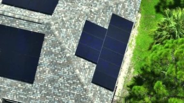 Kenar mahallelerde temiz ekolojik elektrik enerjisi üretmek için çatısı güneş fotovoltaik panellerle kaplı standart bir Amerikan yerleşim evi. Özerk konut kavramı.