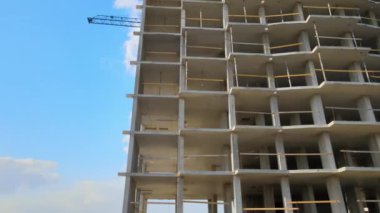 Vinç kaldırma kulesi ve inşaat halindeki monolitik çerçeveli yüksek konutlu bina. Gayrimenkul geliştirme.