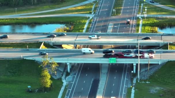 日落时美国农村地区高速公路立交桥与快速行驶的交通车辆和卡车的空中景观 美国州际交通运输基础设施 — 图库视频影像
