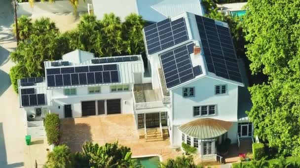 きれいな生態系の電気エネルギーを生成するための青い太陽光発電パネルと新しい高価なアメリカの家の屋根の空中ビュー 排出ゼロをコンセプトとした再生可能エネルギー — ストック動画