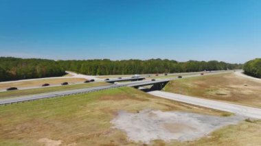 View from above of busy american highway with fast moving traffic between woods. Interstate transportation concept.