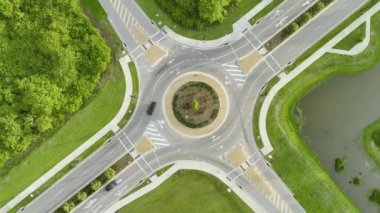 Aerial view of road roundabout intersection with moving cars traffic. Rural circular transportation crossroads.