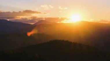 Güzel bir akşam panoramik manzarası. Gün batımında uzak dağ tepeleri üzerinde parlak batan güneş..