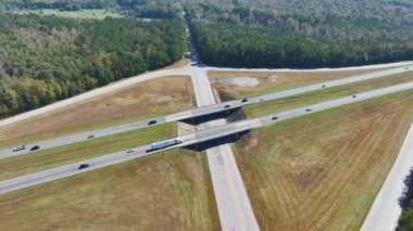 Elevated view of freeway exit junction over road lanes with fast moving traffic cars and trucks. Interstate transportation infrastructure in USA.