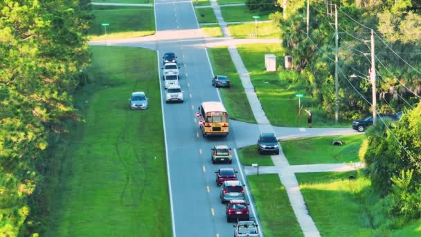 标准的美国黄色校车载着孩子们在镇上的街头小站接孩子们 美国的公共交通 — 图库视频影像