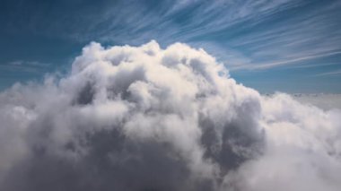 Dünya 'nın yüksek irtifasındaki uçak penceresinden hava manzarası beyaz kabarık kümülüs bulutlarıyla kaplı..