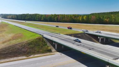 Aerial view of freeway overpass junction with fast moving traffic cars and trucks in american rural area. Interstate transportation infrastructure in USA.