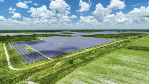 農地と太陽光発電パネルとの間の持続可能な発電所の空中ビューは クリーンな電気エネルギーを生成します 排出ゼロの再生可能エネルギーの概念 — ストック動画