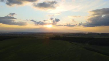 Yeşil tarımsal alanlar arasında elektrik kabloları olan yüksek voltaj kulesi. Elektrik konsepti aktarımı.