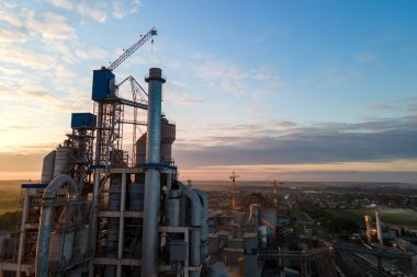 Endüstriyel üretim bölgesinde yüksek beton yapılı çimento fabrikası kulesinin havadan görüntüsü. Üretim ve küresel sanayi kavramı.