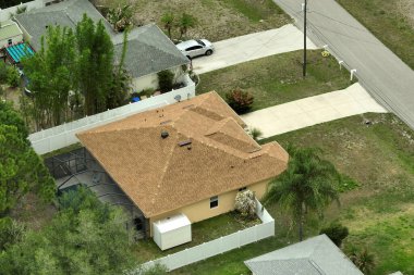 Tipik modern Amerikan özel evinin çatısı asfalt kiremitlerle ve bahçedeki yeşil çimlerle kaplı..